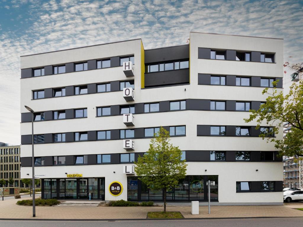 a white building with black windows at B&B Hotel Duisburg Hbf-Süd in Duisburg