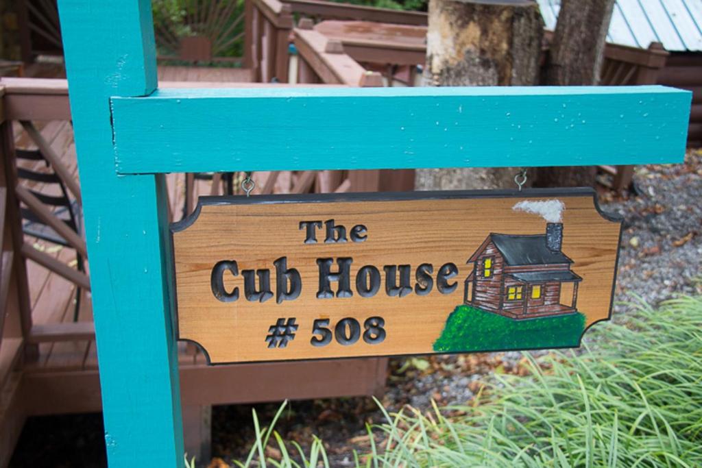 a sign for a club house on a blue bench at 23 The Cub House Cabin in Gatlinburg