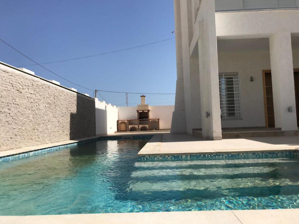 a swimming pool in front of a house at Villa Houmet Souk in Houmt Souk