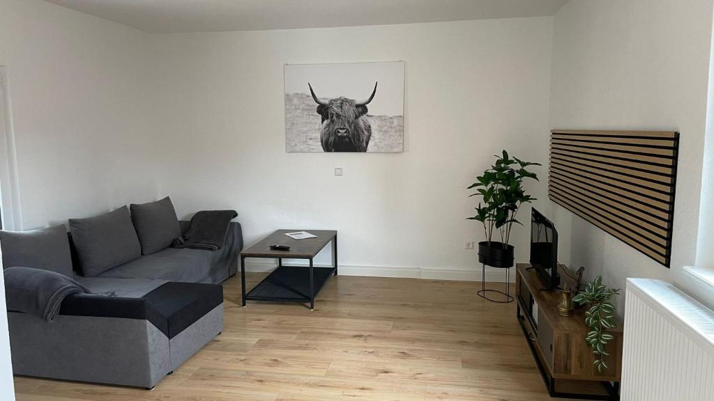 Sala de estar con sofá y cabeza de toro en la pared en Fewo- Daniela en Hauenstein