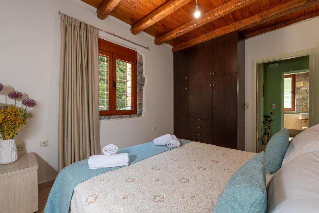 1 dormitorio con 1 cama grande y toallas. en PRINOS GARDEN, en Farsáron