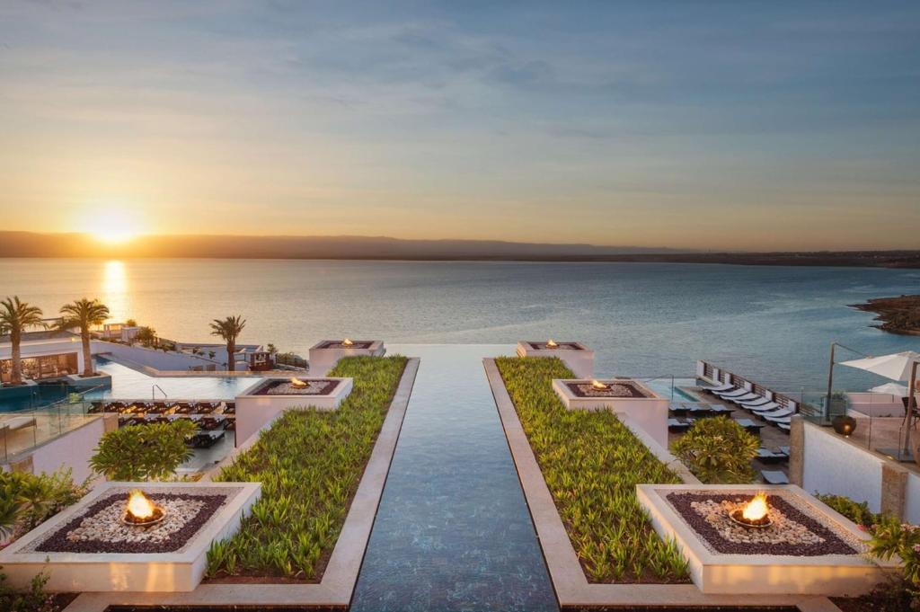 Blick auf ein Resort mit dem Meer im Hintergrund in der Unterkunft Hilton Dead Sea Resort & Spa in Sowayma