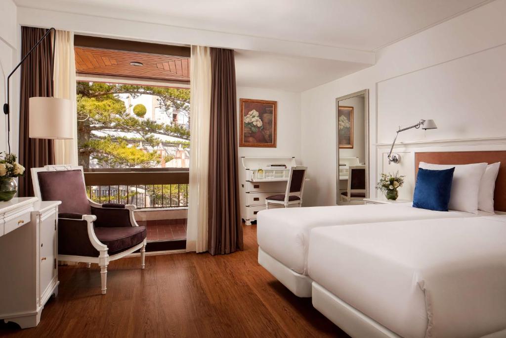 a bedroom with a large white bed and a window at NH Sintra Centro in Sintra