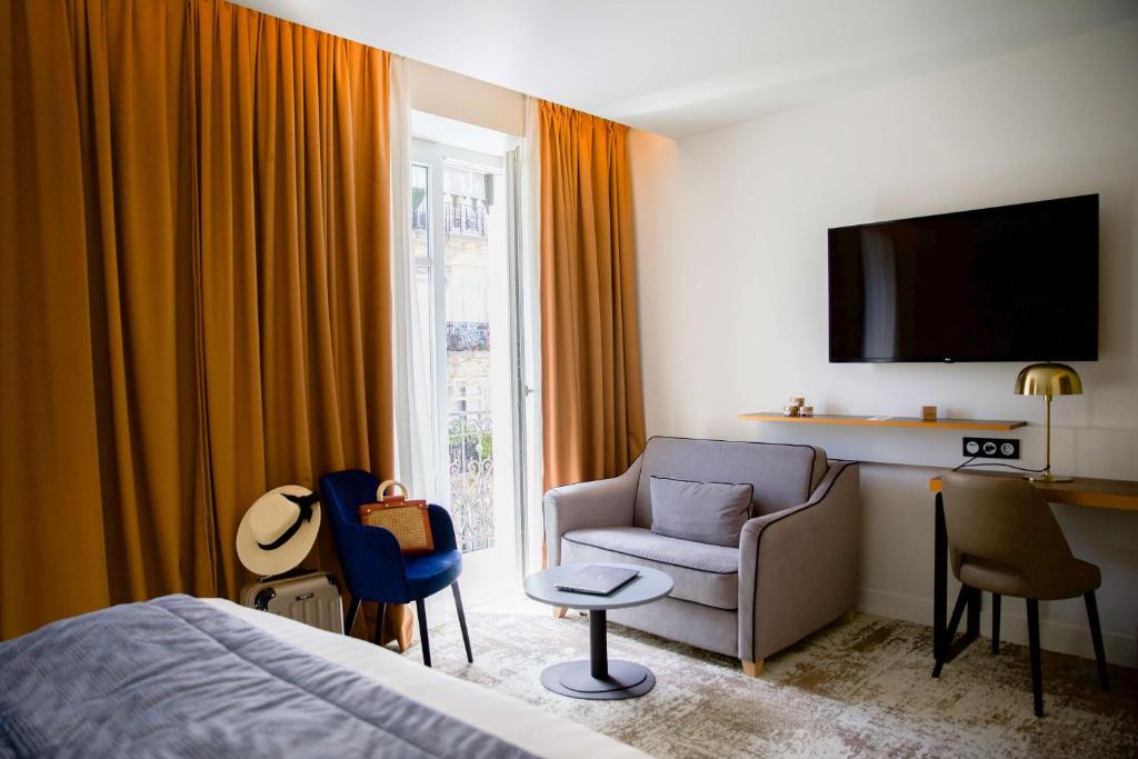een slaapkamer met een bed, een bank en een stoel bij Le Grand Hôtel Grenoble, BW Premier Collection by Best Western in Grenoble