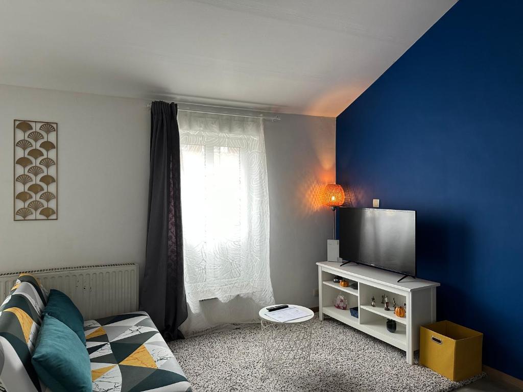 sypialnia z niebieską ścianą i telewizorem w obiekcie Sofieflat - Wallistreet w Charleroi
