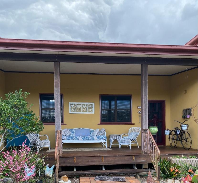 a porch of a house with a couch and chairs at Pomona Noosa Hinterland Homestay in Pomona