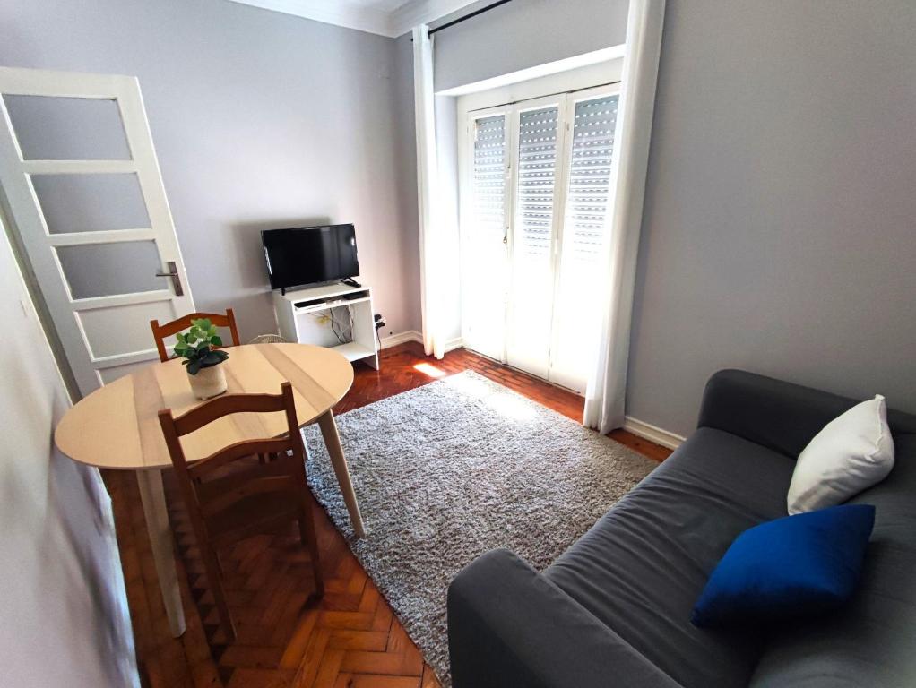 uma sala de estar com um sofá e uma mesa em Lisbon traditional T2 with balcony in Damaia, Lisbon na Amadora