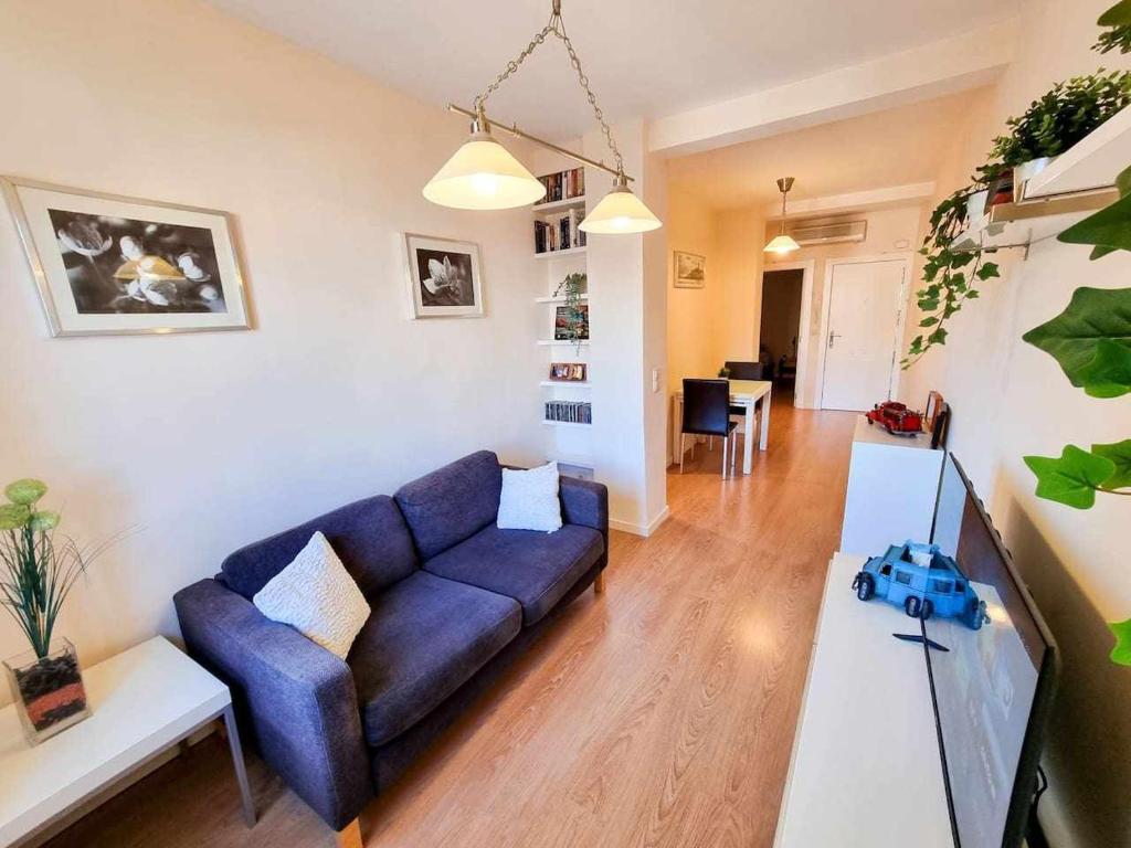 un salon avec un canapé bleu et une table dans l'établissement Centric El Secreto del Pilar ComoTuCasa, à Saragosse