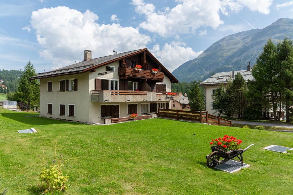 a house in a field with a green yard at Chesa Michela - Champfer in Champfer