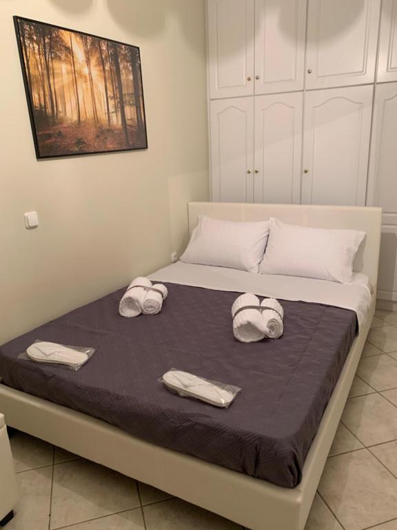 łóżko z dwoma ręcznikami i dwoma kapeluszami w obiekcie Elegant Escapes 3 w Atenach