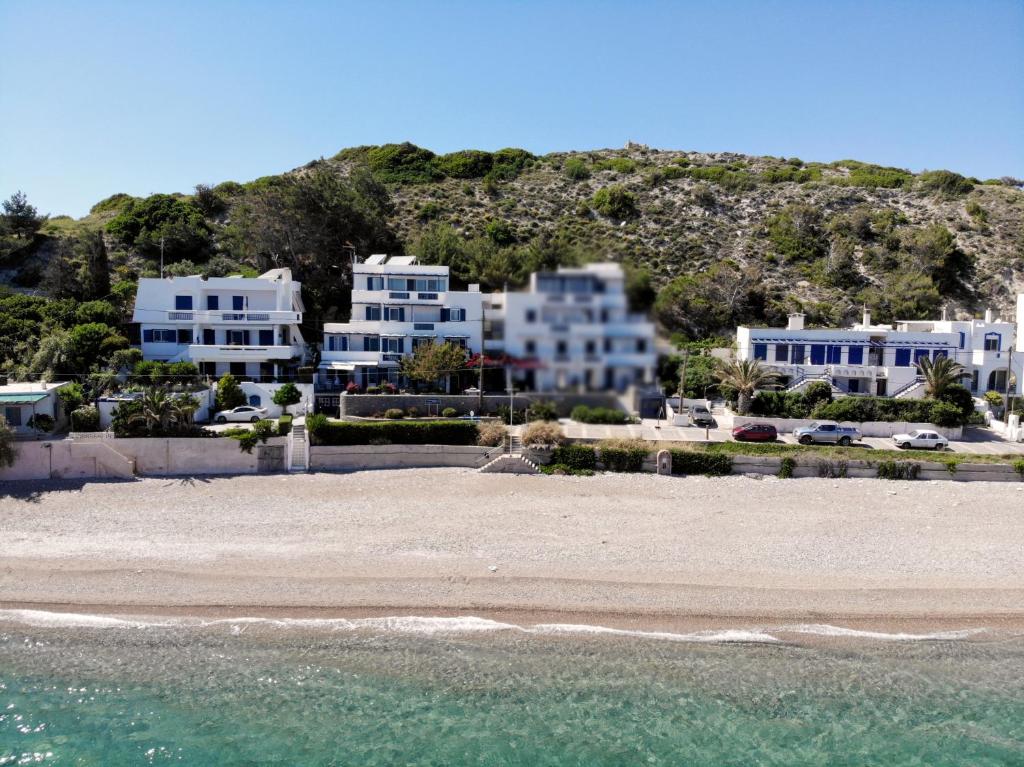 a group of white houses on a beach at Theoxenia Chios Apartments in Paralia Agias Foteinis