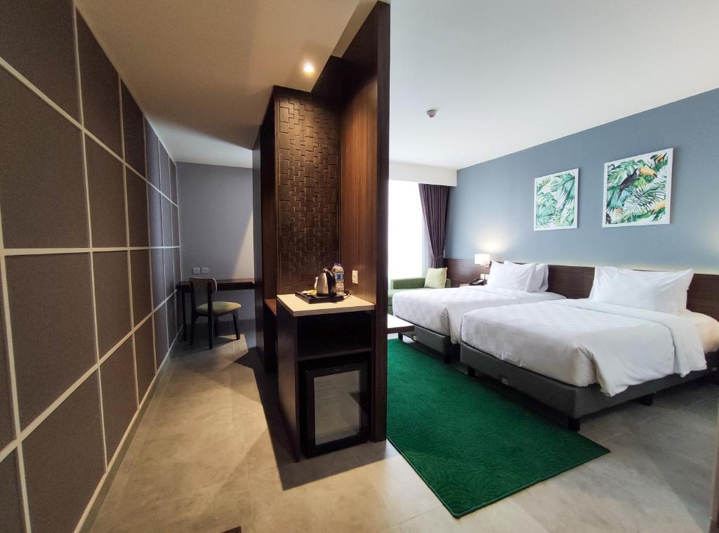 Postel nebo postele na pokoji v ubytování Swiss-Belinn Bogor
