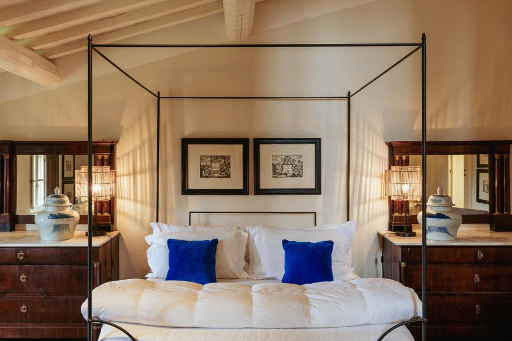 a bedroom with a canopy bed with blue pillows at Exclusive Wine Resort - Villa Dianella in Vinci