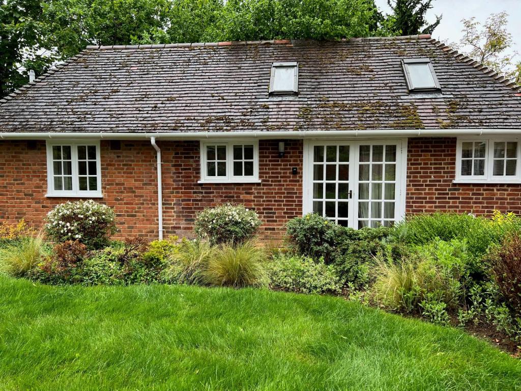 a red brick house with a green yard at The Cherwell Garden Annexe in Oxford