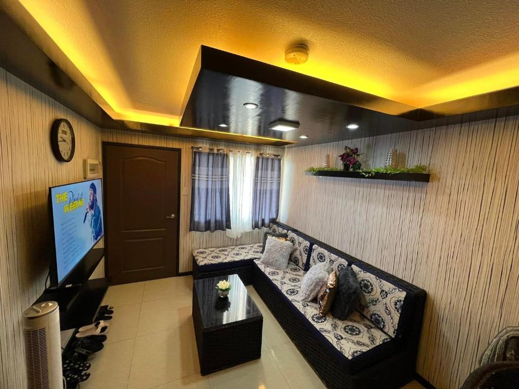 un soggiorno con divano e TV a schermo piatto di One Oasis Condo 2 Bedroom Free Pool & Wifi Beside SM City Mall a Davao