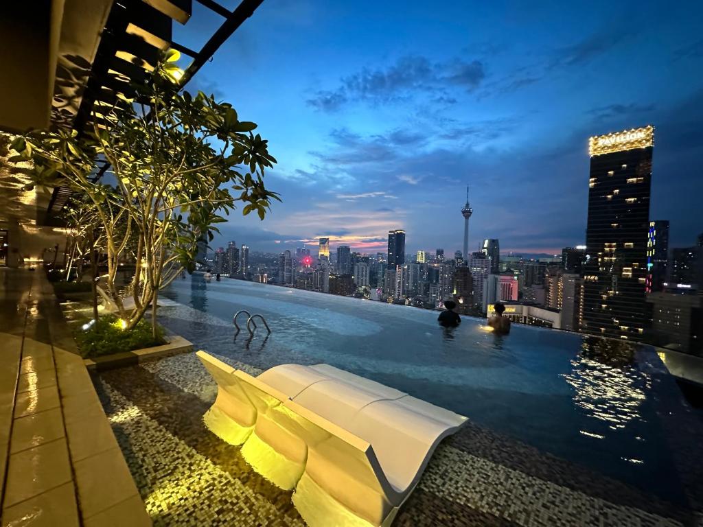 a pool on top of a building with a city skyline at The Axon Suites Bukit Bintang KLCC By SKYSCRAPER in Kuala Lumpur
