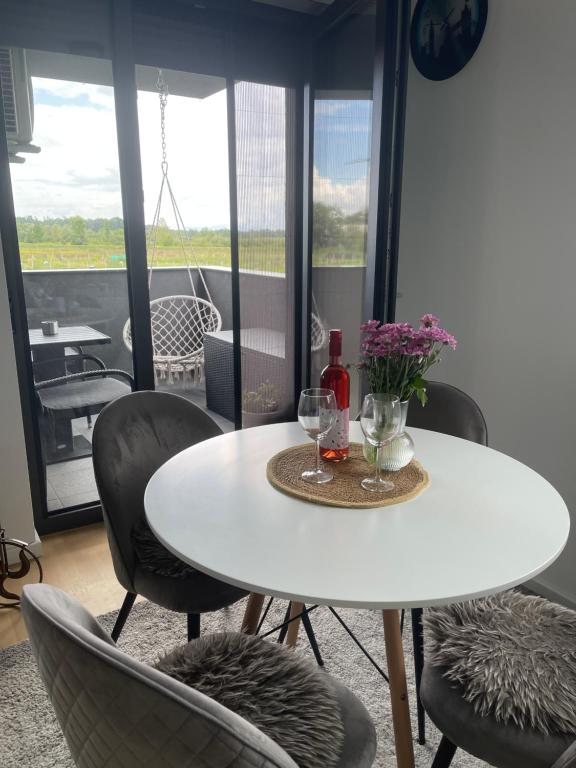 a white table and chairs with wine glasses and flowers at Luna,central,self-check in,AC,WI-FI, washer,free parking in Zaprešić