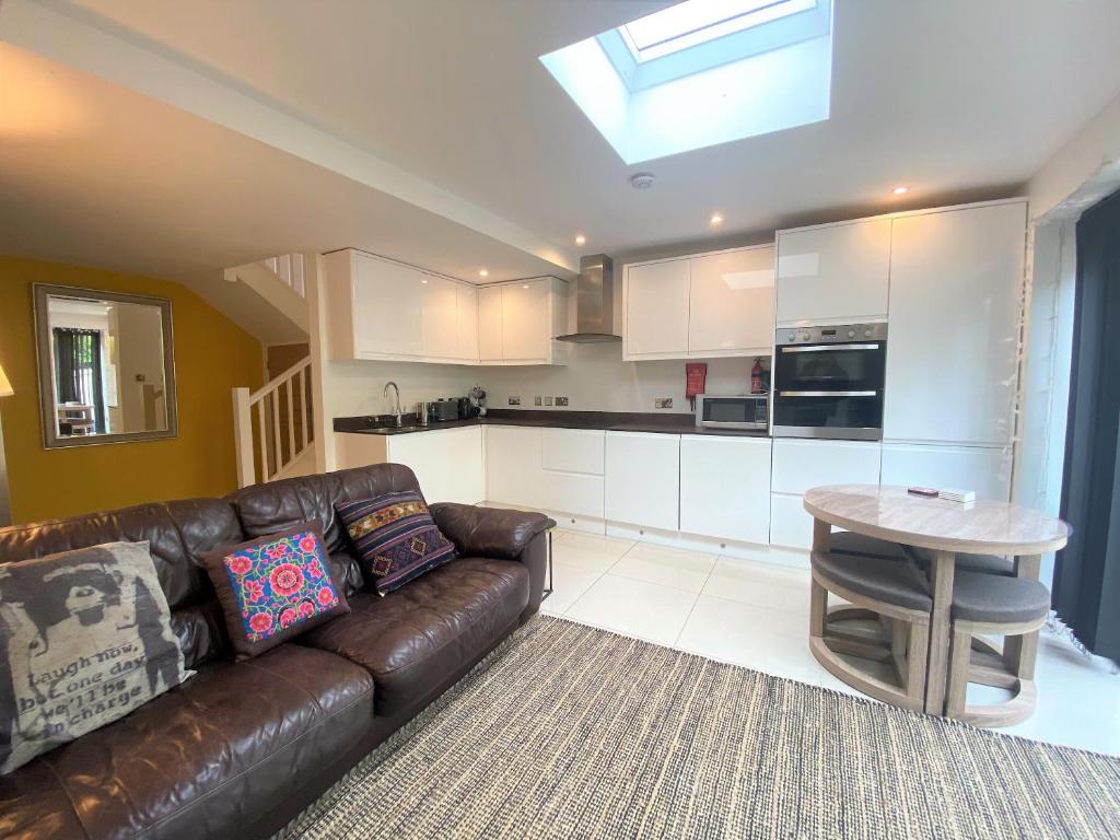sala de estar con sofá de cuero marrón y mesa en Contemporary Eco-Home near Bristol Harbourside en Bristol