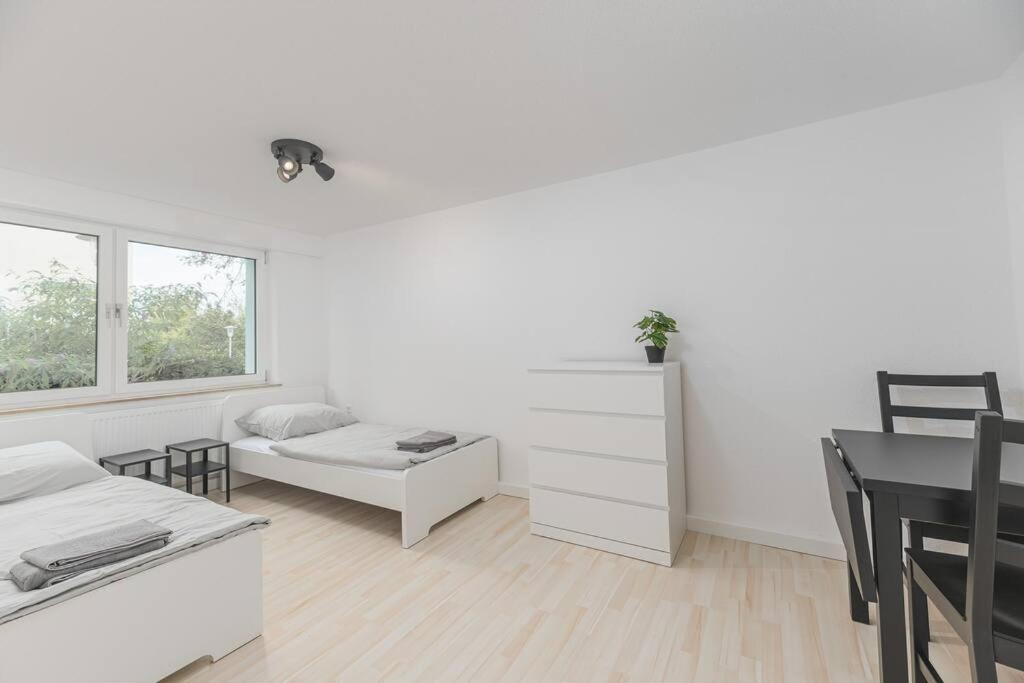 a white living room with a table and a couch at NT01 schönes Appartement - ideal für Teams Self Check-In in Nürtingen