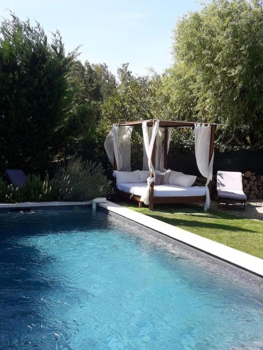 - une piscine avec une balançoire et des chaises à côté dans l'établissement le cabanon tendance du Luberon, à Mérindol