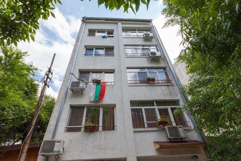 a tall white building with windows and plants at Samuil Apartments in Burgas City