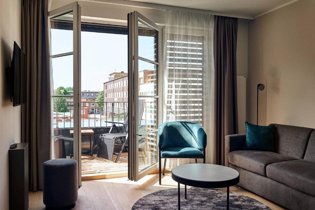 a living room with a couch and a view of a balcony at Makro Apartments in Hamburg