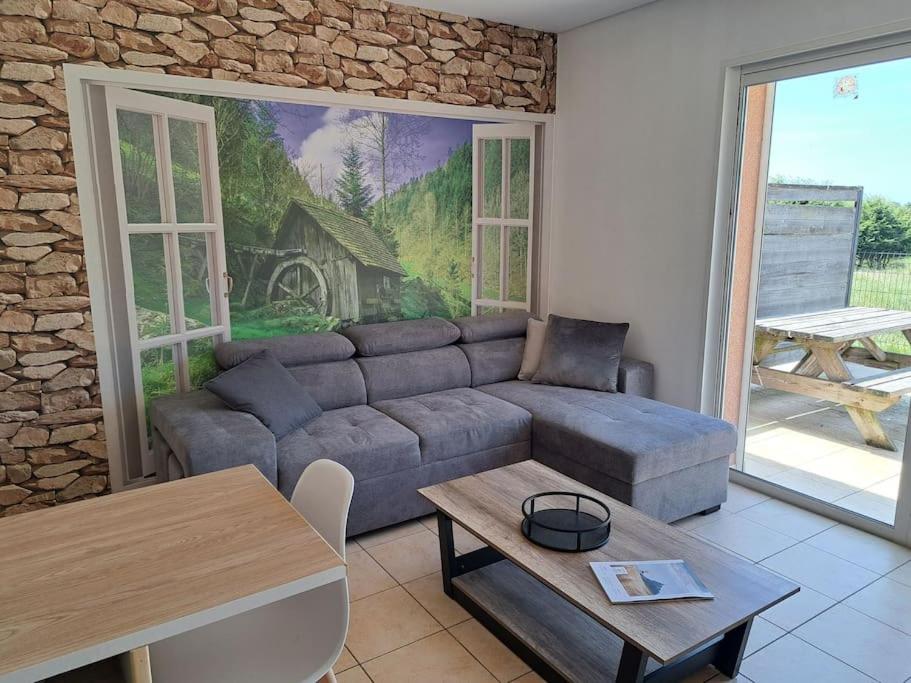 uma sala de estar com um sofá e uma mesa em Le Nature em Huisnes-sur-Mer