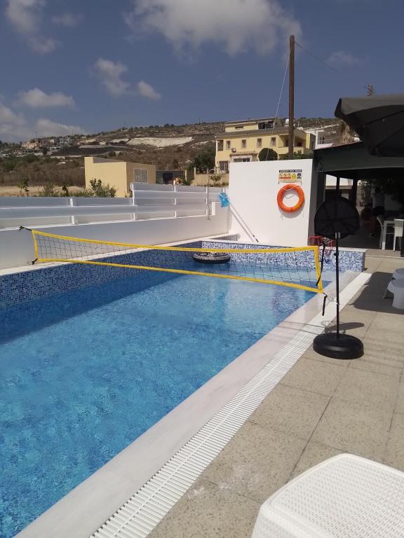 uma piscina com rede de voleibol no topo de um edifício em Michael Angelo Villa em Pafos
