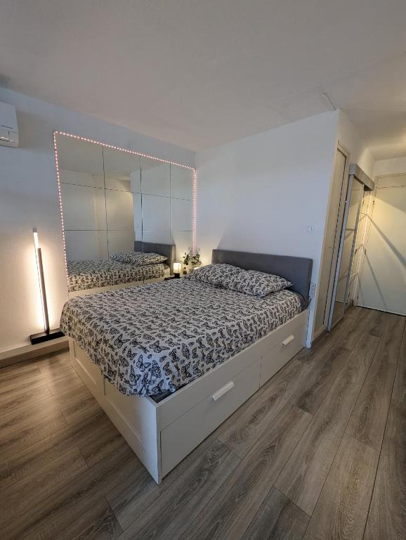 une chambre avec un grand lit avec un grand miroir dans l'établissement Studio avec terrasse Heliopolis, au Cap d'Agde