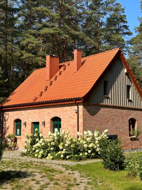 a brick house with an orange roof at UTASIÓWKA Mazury in Pasym