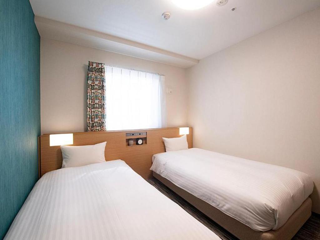 Postel nebo postele na pokoji v ubytování Nest&Rise Osaka Namba Hotel