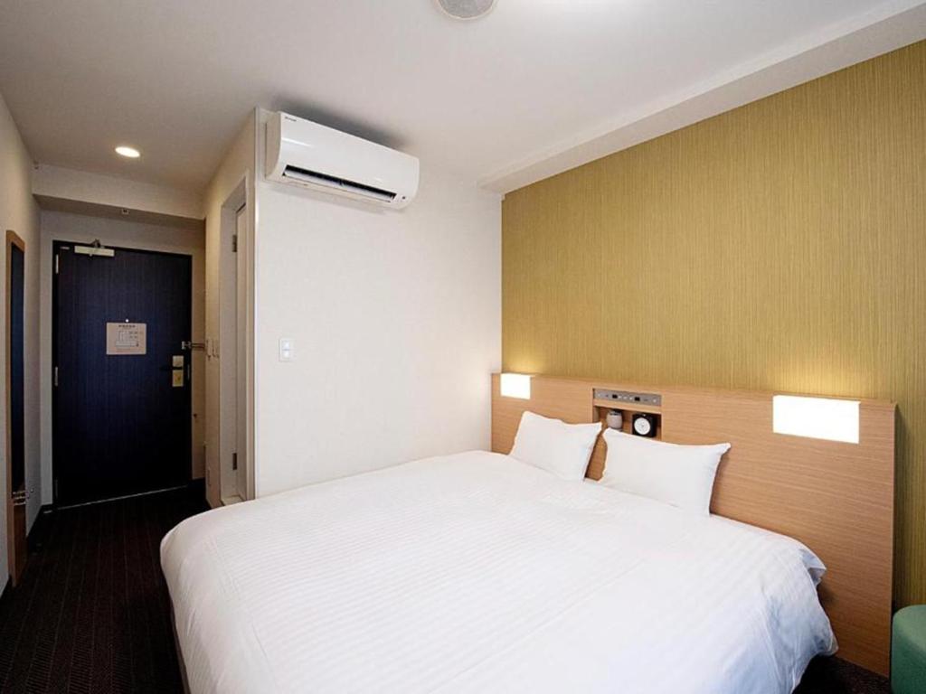 Postel nebo postele na pokoji v ubytování Nest&Rise Osaka Namba Hotel
