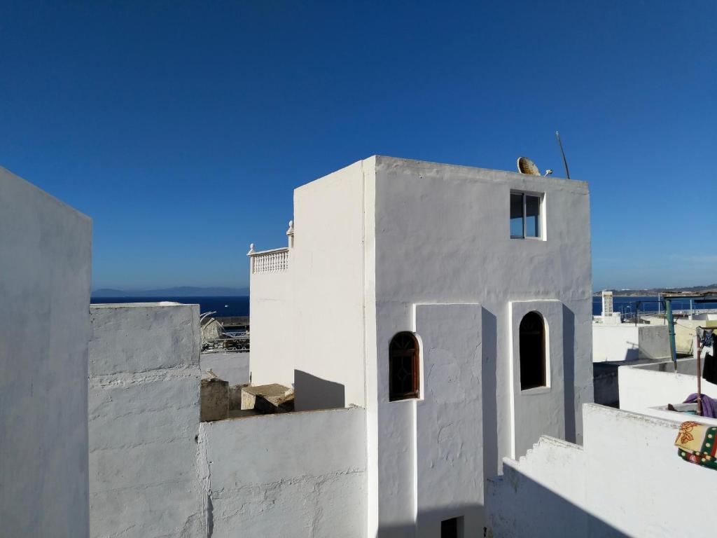 un bâtiment blanc avec un ciel bleu en arrière-plan dans l'établissement Dar Gara, à Tanger