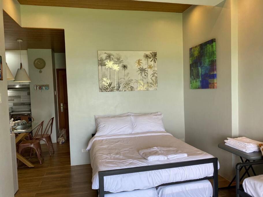 a bedroom with a bed in a room with a table at Modern Unit Near The Beach at Canyon Cove Nasugbu in Nasugbu