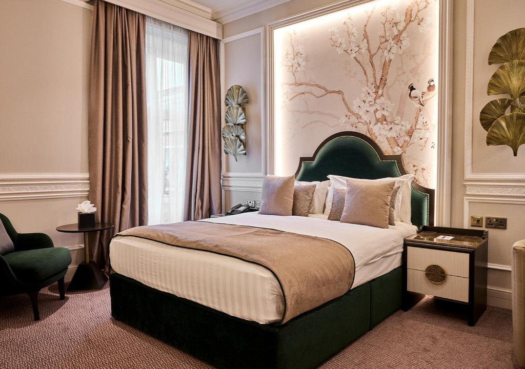 a bedroom with a large bed with a green headboard at Warren House Hotel in Kingston upon Thames