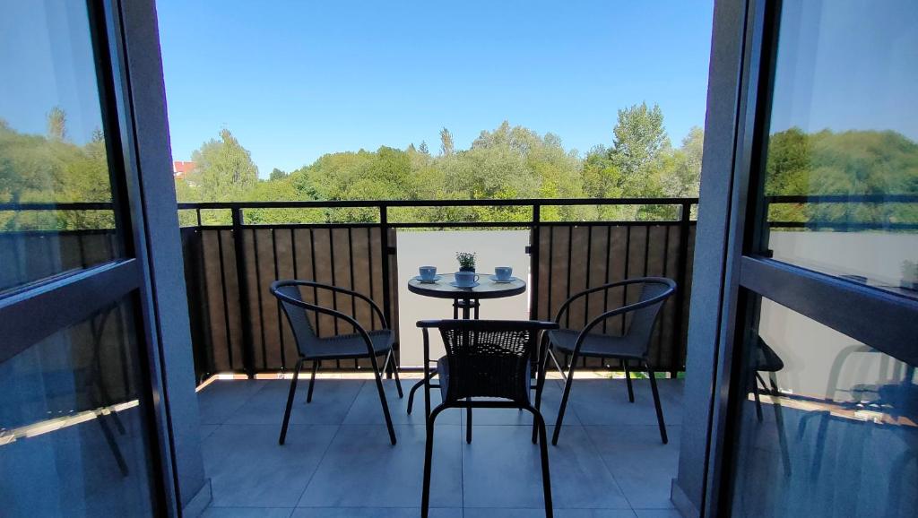 a patio with a table and chairs on a balcony at Apartament Azul in Cieszyn