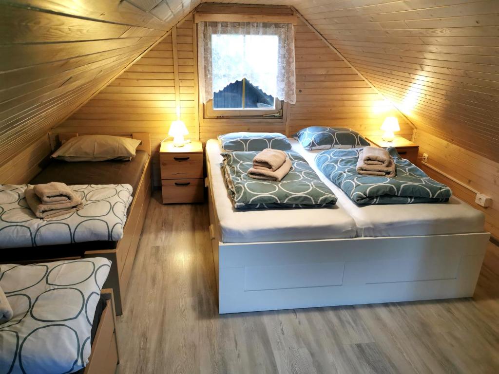 um quarto com 2 camas num chalé de madeira em Cosy Retreat Čatež em Catez ob Savi