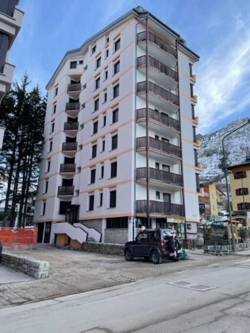 a large white building with a car parked in front of it at Appartamento Kern-Sciare A Portata Di Mano- in Madesimo