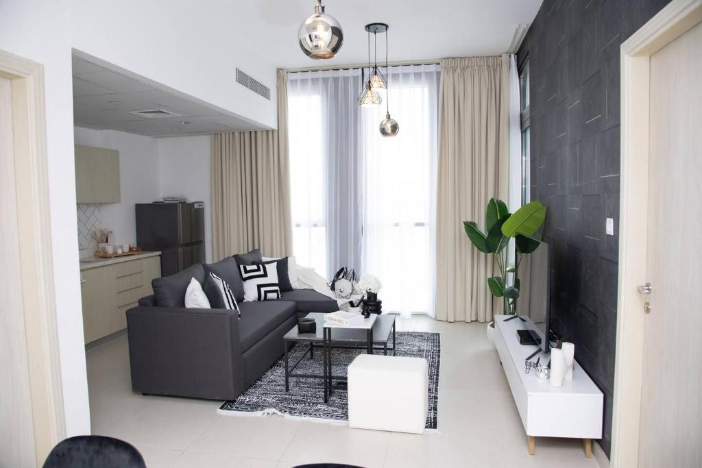 ein Wohnzimmer mit einem Sofa und einem Tisch in der Unterkunft Tamm - Luxe Condo With Balcony and Incredible City Views in Dubai