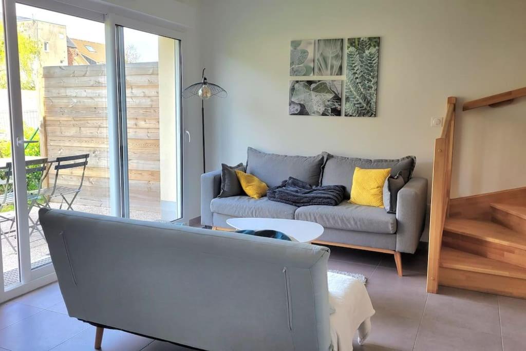 uma sala de estar com um sofá e uma mesa em Maison avec jardin sur Berck em Berck