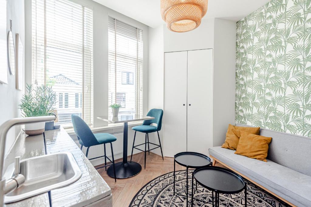 cocina con sofá, sillas y mesa en Studio Estelle's with Private Parking, en Zandvoort