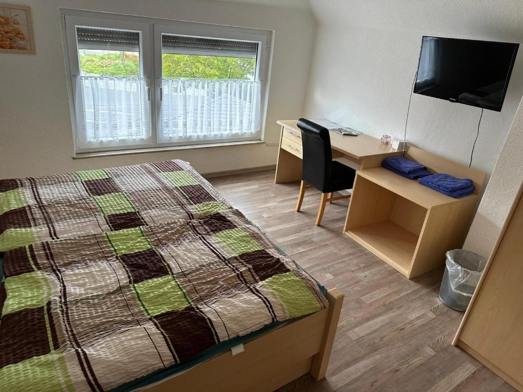Schlafzimmer mit einem Bett und einem Schreibtisch mit einem Computer in der Unterkunft Zentrale Doppelbettzimmer in Nordenham