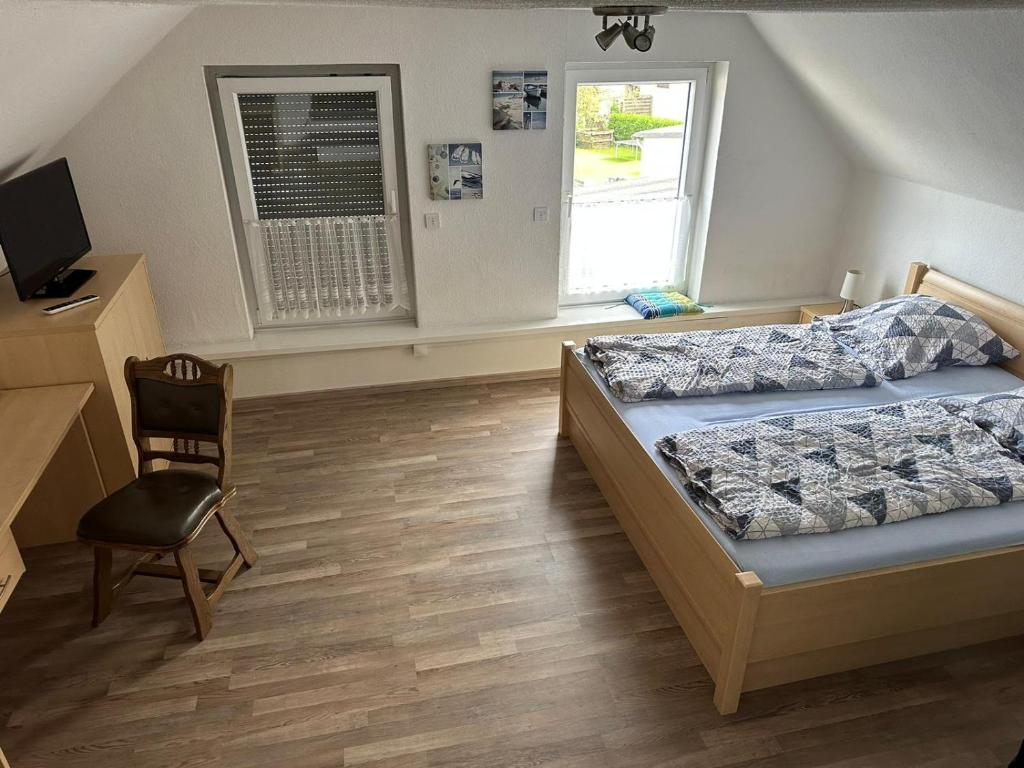 1 Schlafzimmer mit 2 Betten, einem Stuhl und einem Fenster in der Unterkunft Zentrale Doppelbettzimmer in Nordenham