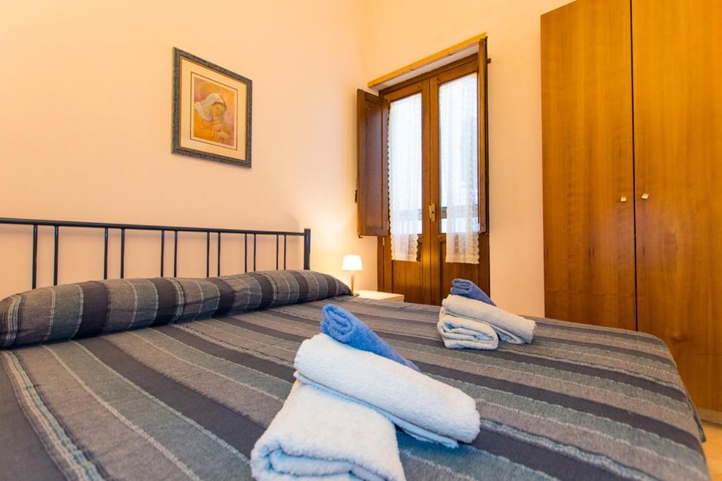 a bedroom with two beds with blue towels on them at La casetta di Lula in Trapani