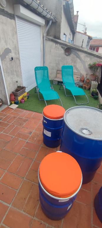 - une terrasse avec 2 toilettes et chaises bleues et oranges dans l'établissement Maison de village 2 chambres terrasse et garage, à Saint-Paul-de-Fenouillet