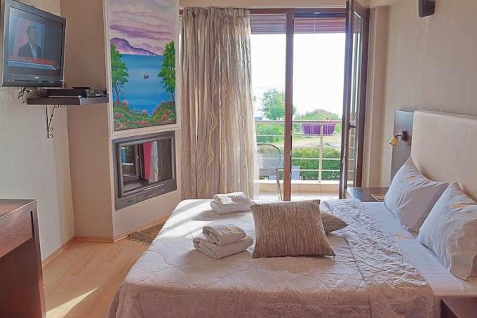 a bedroom with a bed and a large window at Agathoupoli beach 