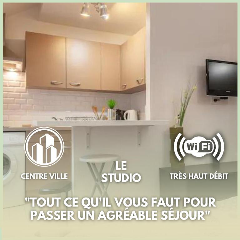 Il comprend une cuisine avec des placards blancs et une télévision murale. dans l'établissement Le studio - Hyper centre de Fontainebleau - proche INSEAD, à Fontainebleau