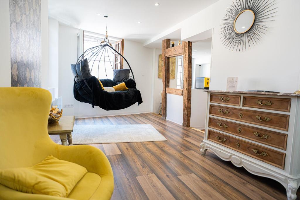 ein Wohnzimmer mit einer an der Decke hängenden Schaukel in der Unterkunft Appartement de la noblesse - designed by C.M in Sélestat