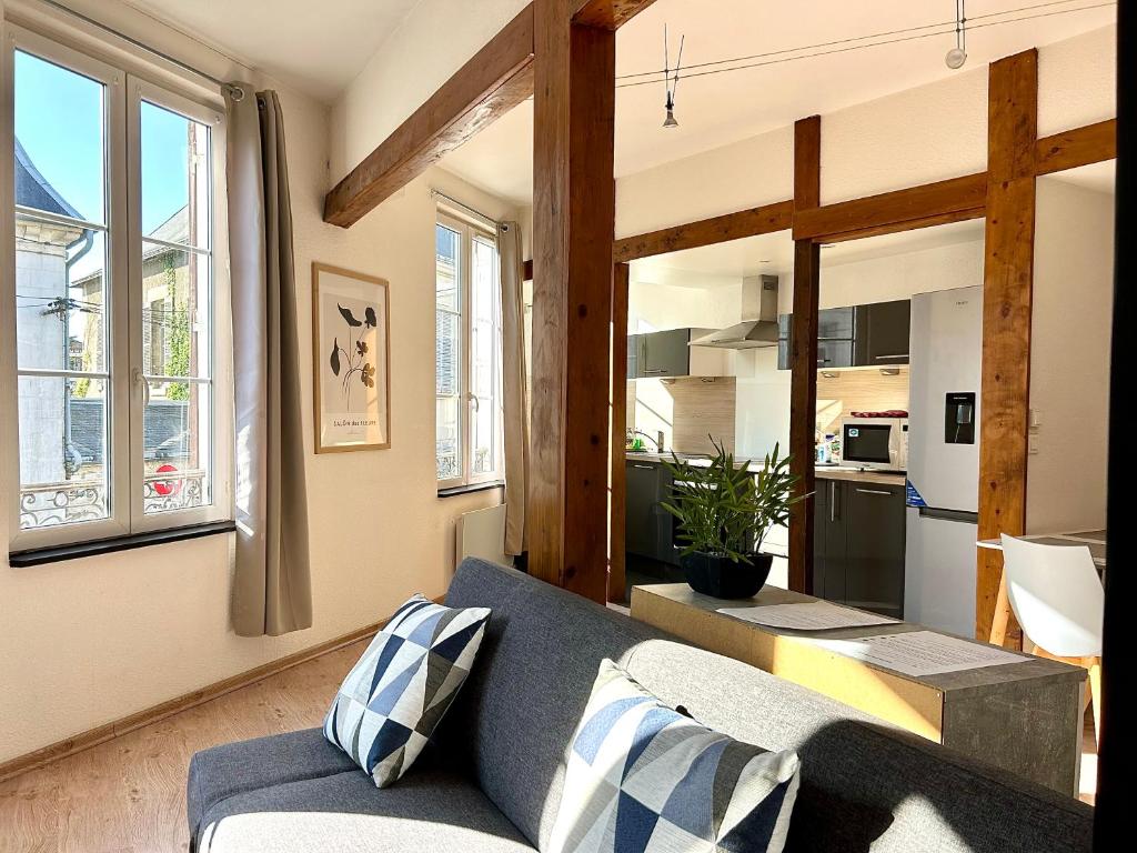 a living room with a couch and a kitchen at L&#39;appartement du Centre in Chalons en Champagne