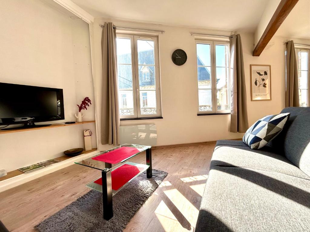 a living room with a couch and a table at L&#39;appartement du Centre in Chalons en Champagne